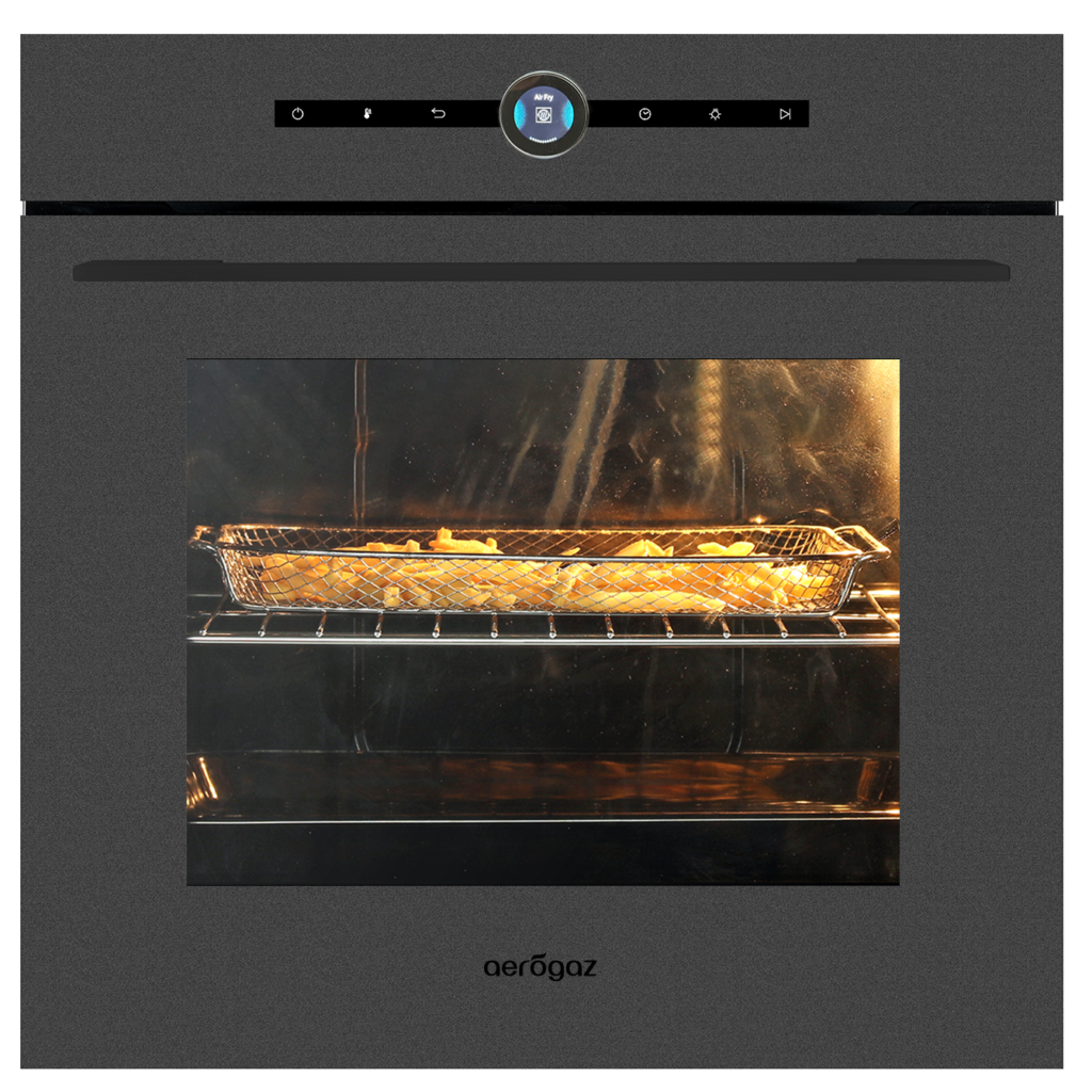 French fries roasting in a metal basket inside an oven, warm light glowing on the fries.
