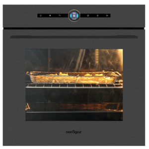 French fries roasting in a metal basket inside an oven, warm light glowing on the fries.
